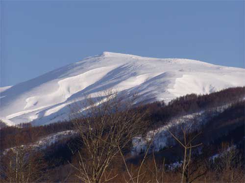 快晴に浮く月山